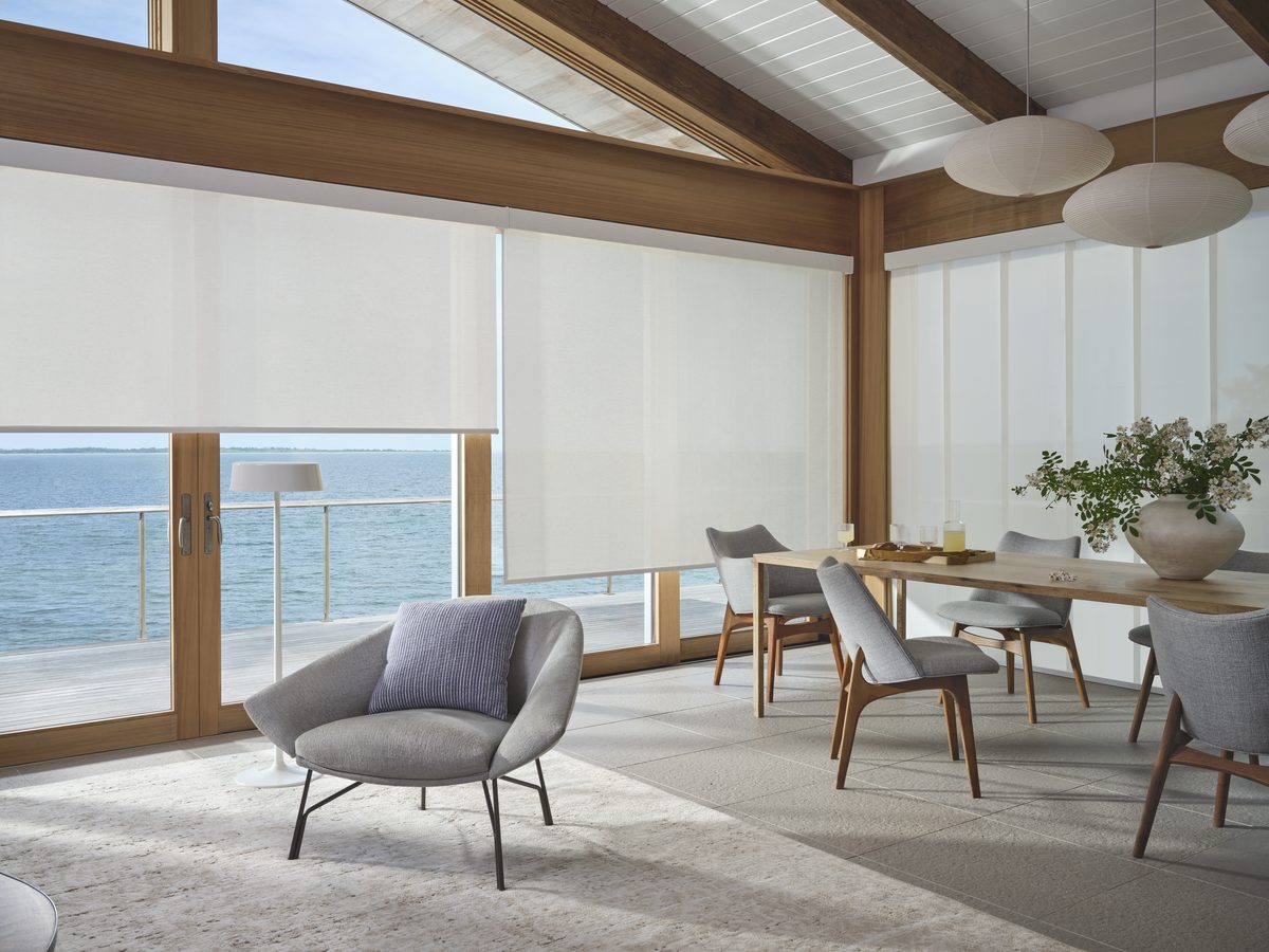 Modern coastal great room with floor-to-ceiling Hunter Douglas roller shades and ocean view